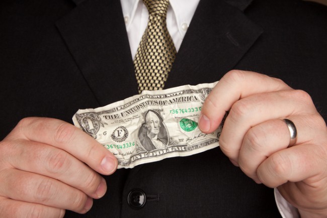 Businessman with Coat and Tie Holding Wrinkled United States Dollar Bill.